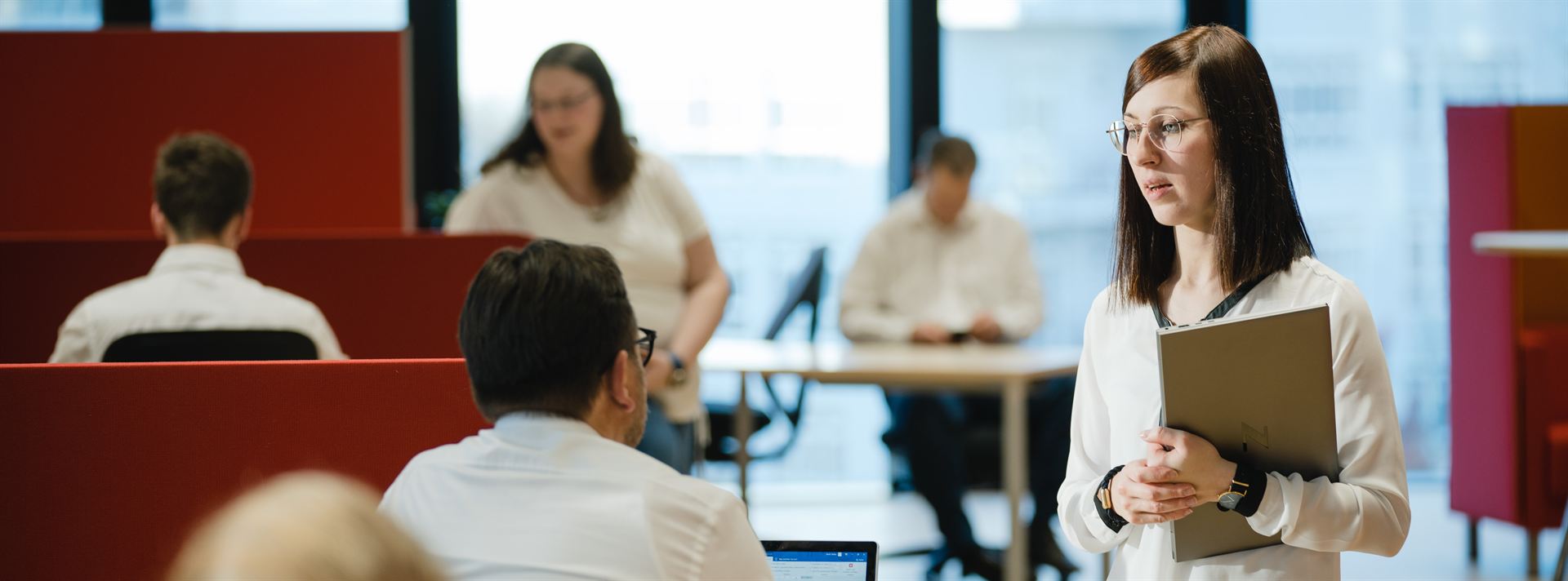LEANIO Mitarbeiterin mit Unterlagen im Büro